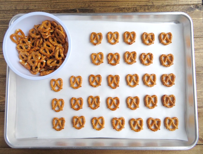 Laying out pretzels on a baking sheet lined with parchment paper