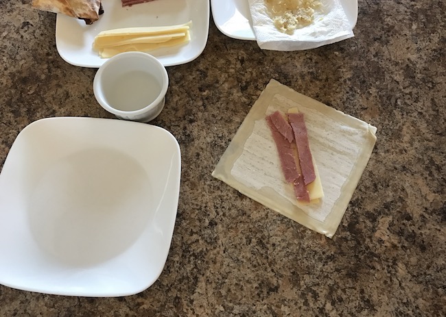 Air Fryer Reuben Egg Rolls recipe for St. Patrick's Day is filled with Corned Beef, Melted Swiss Cheese, Sauerkraut and dipped in 1000 Island dressing.