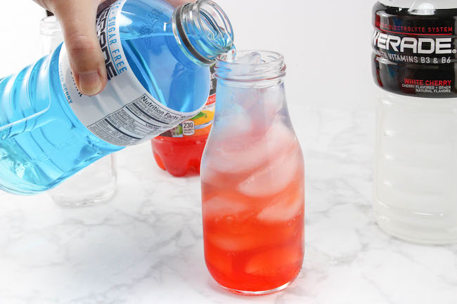 The Patriotic Red, White and Blue Layered Drink Recipe is easy to make. The key is the sugar content in the drinks and to pour them over ice so they don't mix.