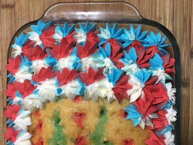 Piping stars on patriotic poke cake